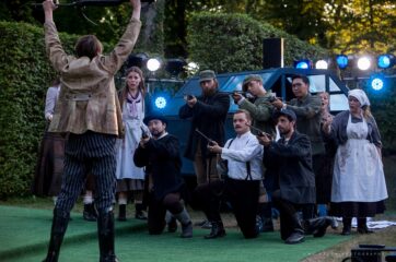 Open-air Vorstellung von Der Freischütz im Heckentheater 2018. Männer mit Gewehren zielen auf einen Mann mit erhobenen Händen.